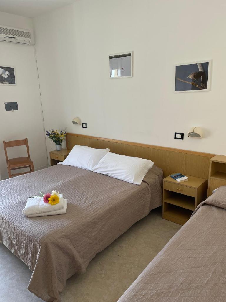 - une chambre avec un lit et un plateau de fleurs dans l'établissement HOTEL LA PLAYA, à Cervia