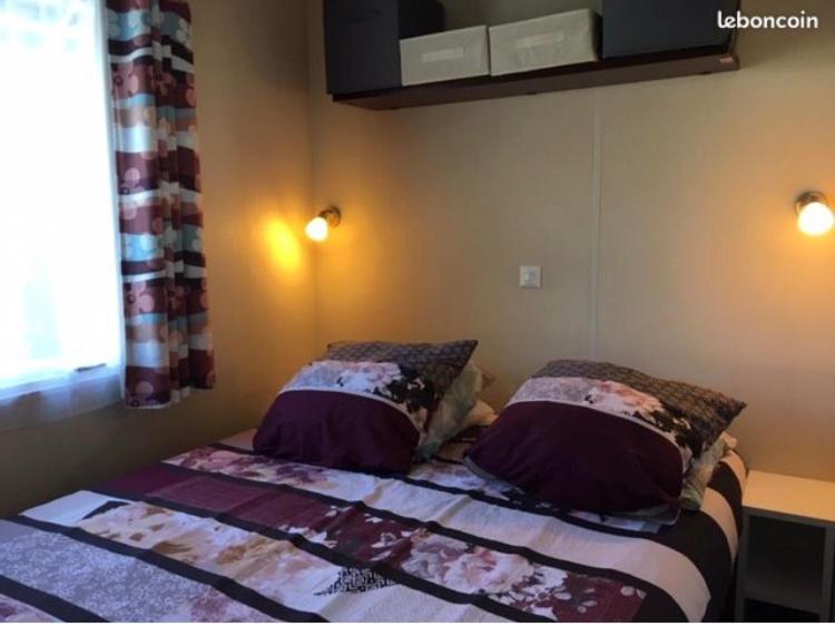 une chambre avec un lit avec deux oreillers dessus dans l'établissement chez Sodam by siblu, à Parentis-en-Born