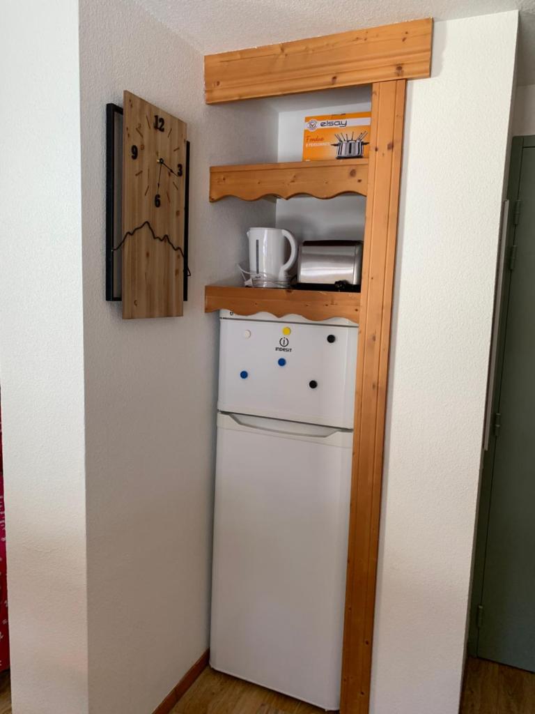 un réfrigérateur dans une cuisine avec une étagère au-dessus. dans l'établissement Appartement Chamrousse, à Chamrousse 12 autres photos