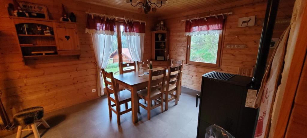 une salle à manger avec une table et des chaises dans une cabine dans l'établissement Chalet de la Grimpette au coeur de Gérardmer, à Gérardmer