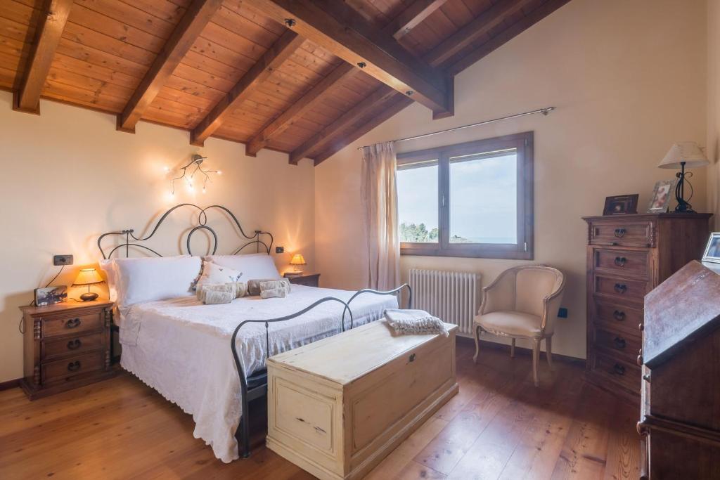 une chambre avec un lit, une chaise et une fenêtre dans l'établissement La Nocciola by PosarelliVillas, à Cereto
