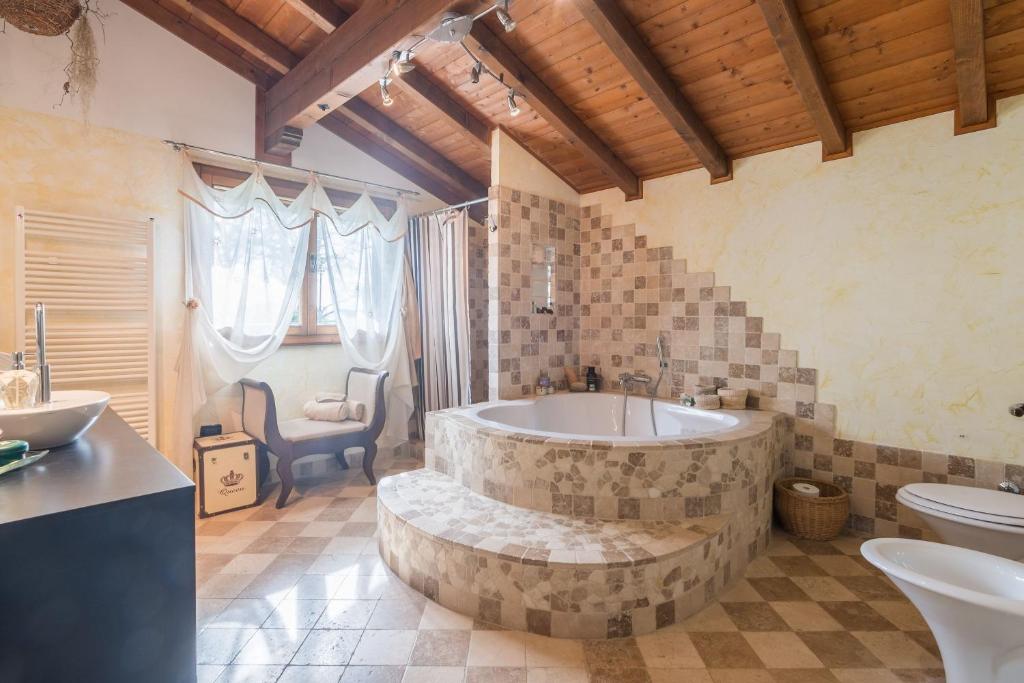 La grande salle de bains est pourvue d'une baignoire et de toilettes. dans l'établissement La Nocciola by PosarelliVillas, à Cereto
