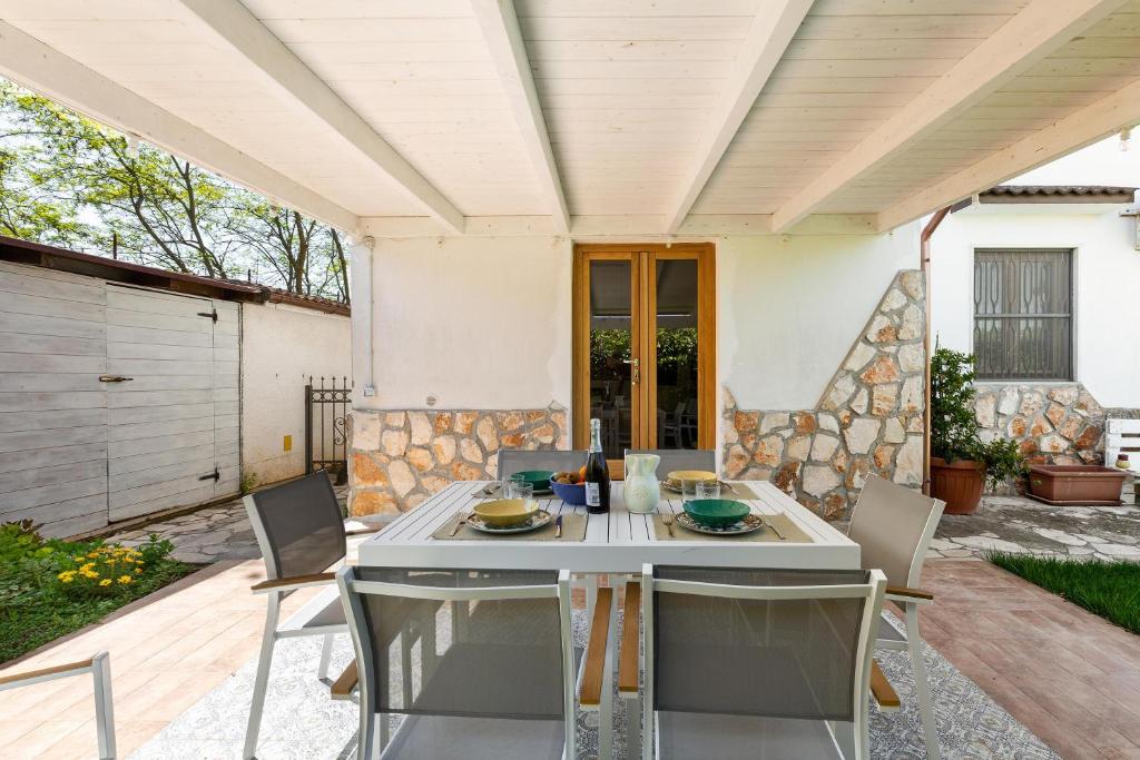 d'une terrasse avec une table et des chaises blanches. dans l'établissement Villa San Donato by BarbarHouse, à San Donato