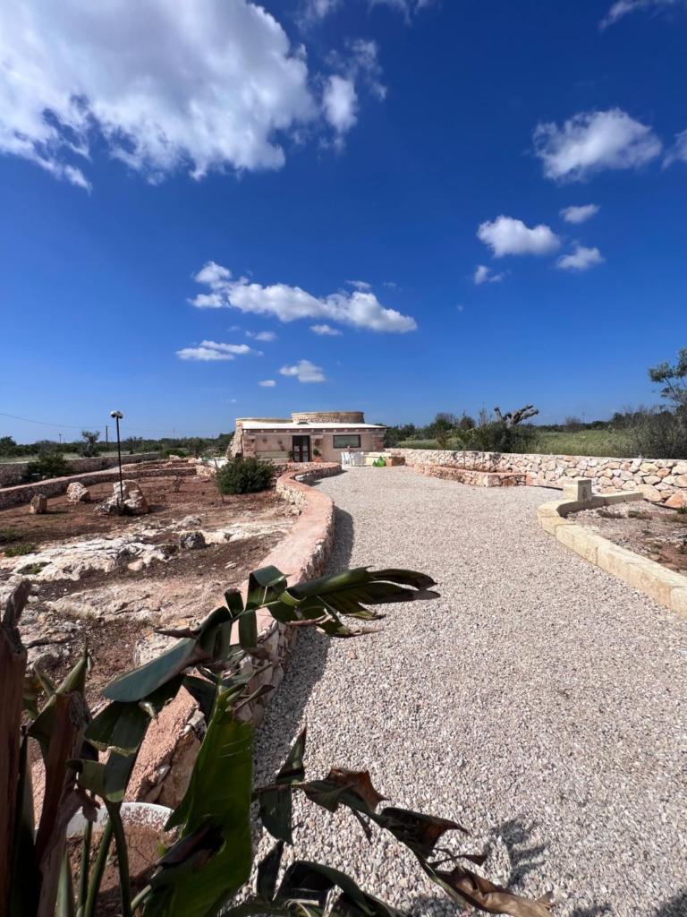 une route en gravier avec un bâtiment en arrière-plan dans l'établissement I Trulli di Giorgia, à Torre Suda