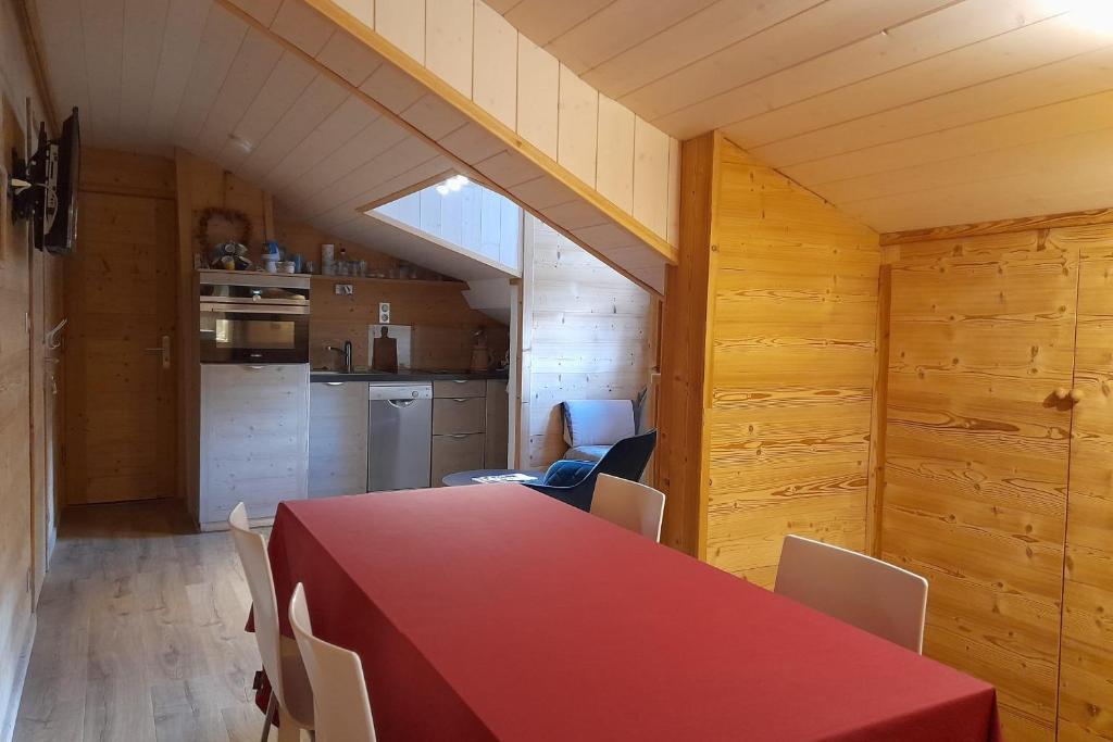 une salle à manger avec une table et des chaises rouges dans l'établissement Apartment in the center of the village, à La Clusaz