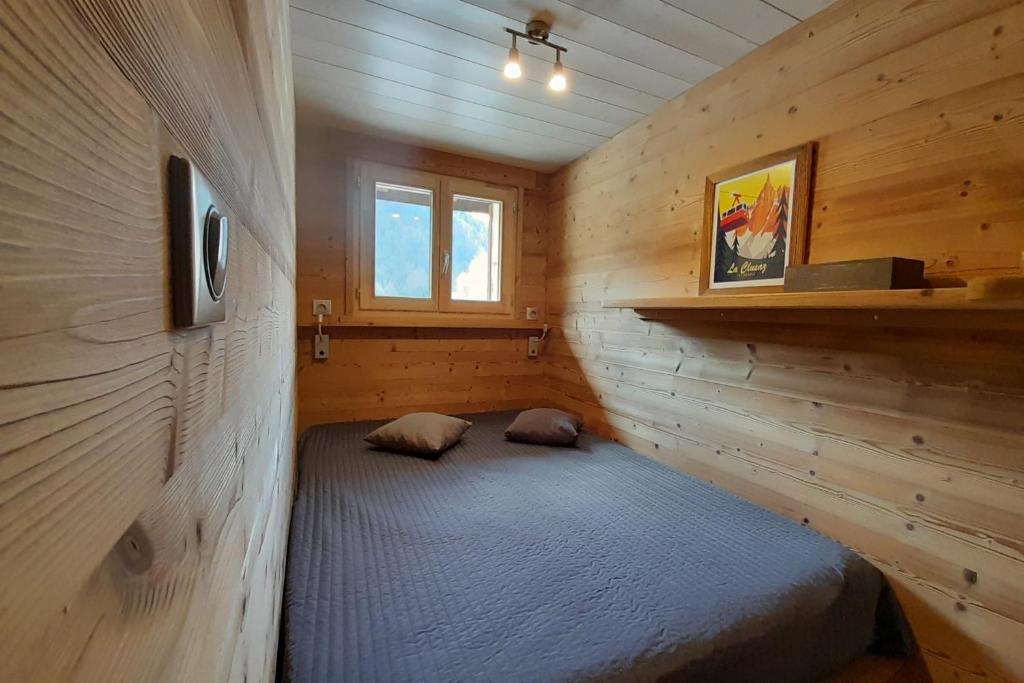 une chambre avec un lit dans une cabane en bois dans l'établissement Apartment in the center of the village, à La Clusaz