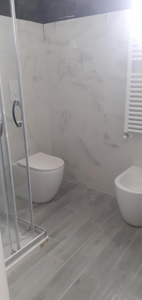 une salle de bain blanche avec toilettes et lavabo dans l'établissement Palazzo Galante, à Margherita di Savoia