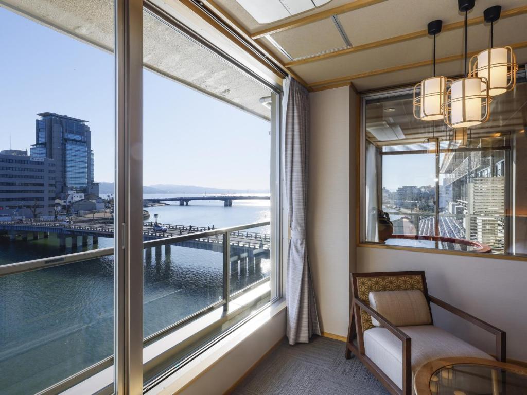 Cette chambre dispose d'une grande fenêtre offrant une vue sur un pont. dans l'établissement Ohashikan, à Matsue