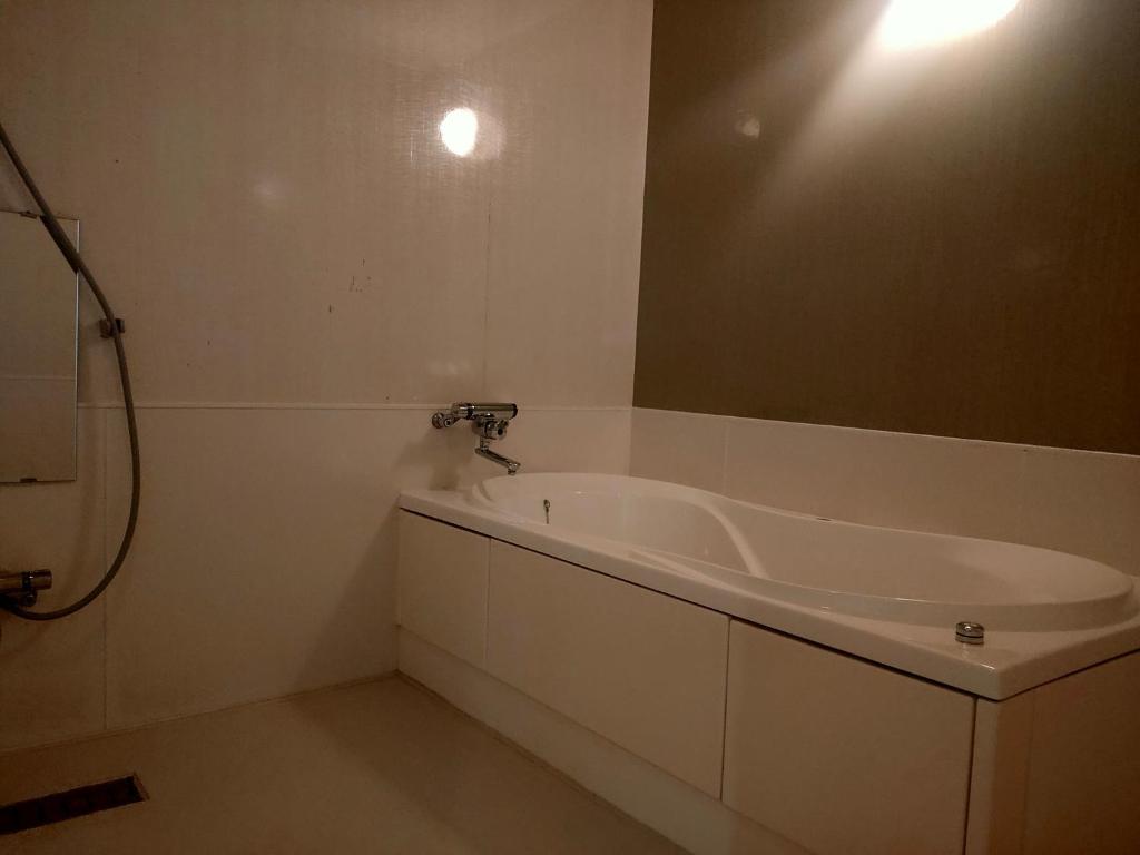 une salle de bain avec une baignoire et un miroir dans l'établissement HOTEL TWO HEART - Adult Only, à Fukushima 2 autres photos