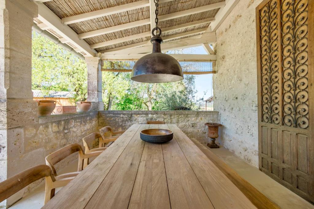 une salle à manger avec une table en bois et un éclairage tamisé dans l'établissement Gîte du Domaine de Roujol, à Brassac