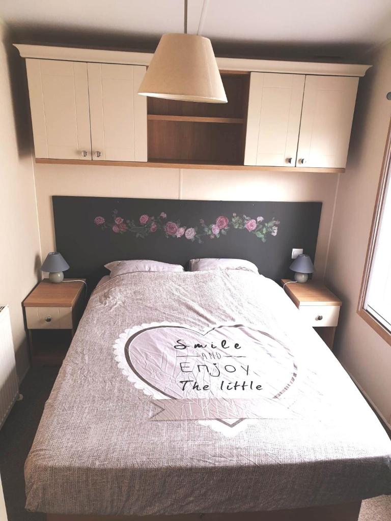 une chambre avec un lit avec une couverture blanche et des fleurs roses dans l'établissement L'Exellence, à Fréjus 29 autres photos