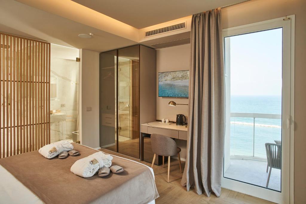 une chambre d'hôtel avec un lit avec vue sur l'océan dans l'établissement Hotel Sans Souci, à Gabicce Mare