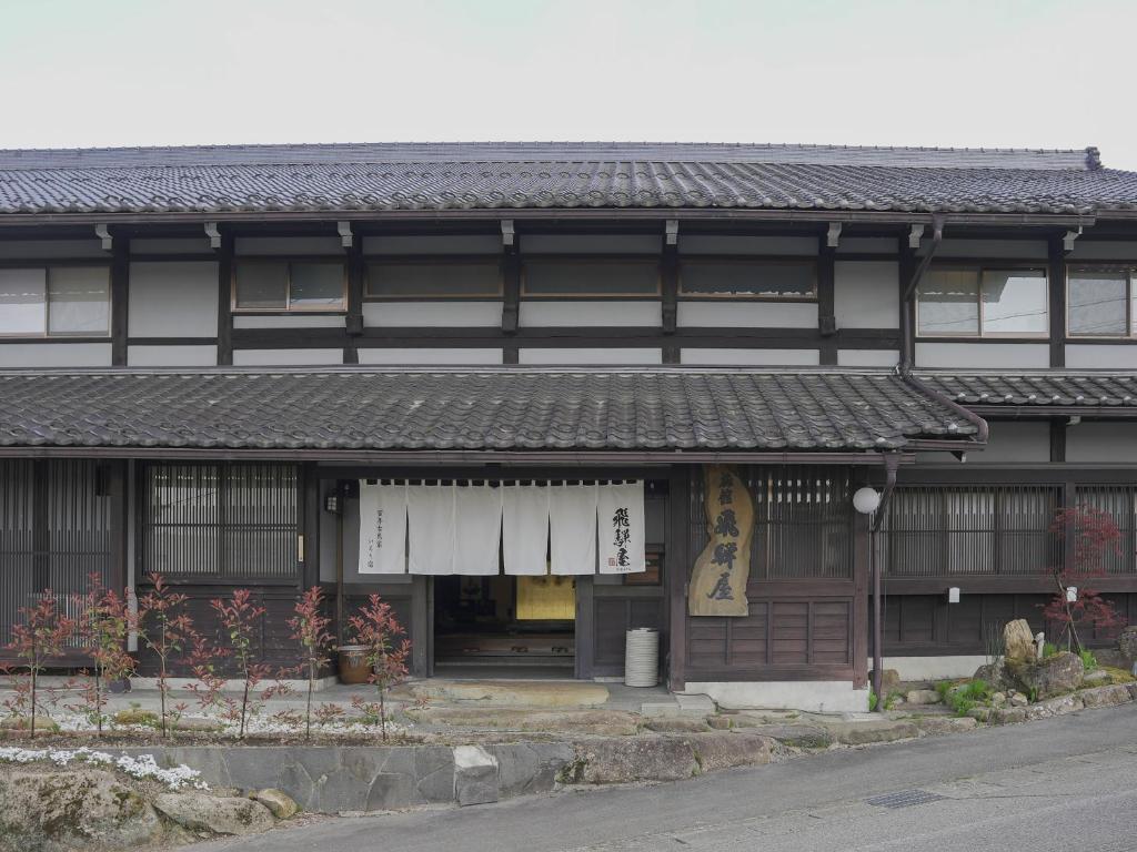 un bâtiment de style asiatique avec un panneau sur lui dans l'établissement Iroriyado Hidaya, à Takayama