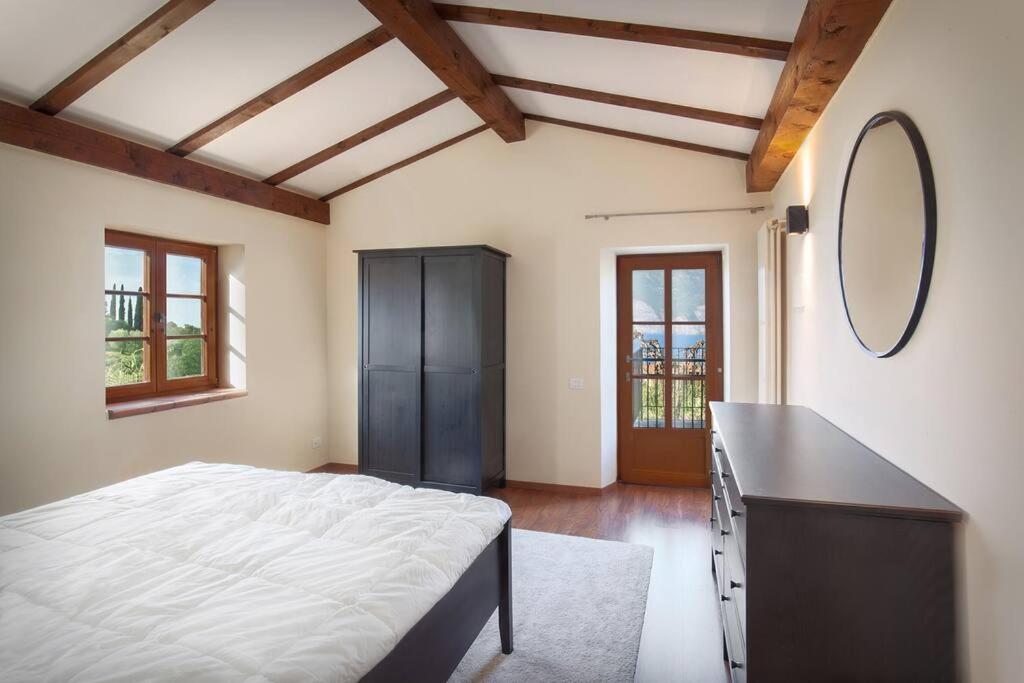 une chambre avec un lit, une commode et un miroir dans l'établissement Villa Fuzzys - Un antico casale ristrutturato, à Malcesine 42 autres photos