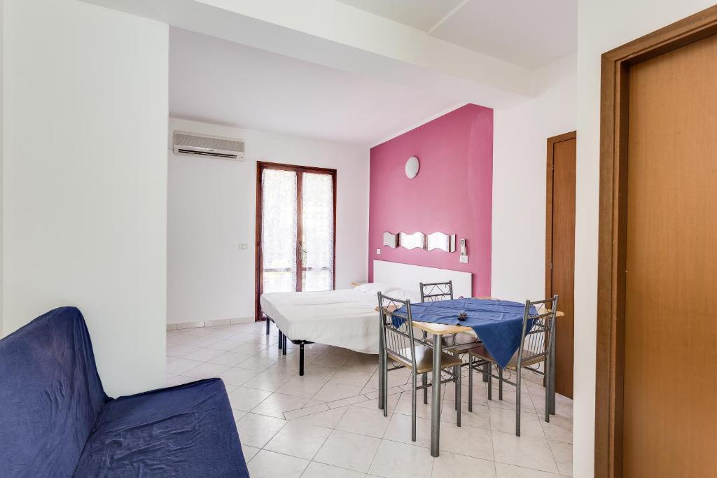 une salle à manger avec une table et des chaises bleues dans l'établissement Residence Blu Marlin Natural free beach, à Lido Adriano