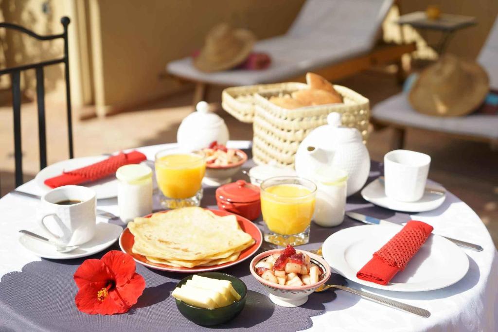 - une table avec des aliments pour le petit-déjeuner et du jus d'orange dans l'établissement Dar Alif, à Marrakech