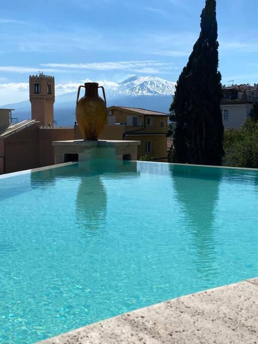 une piscine avec un vase au sommet d'un immeuble dans l'établissement Atelier Taormina spacious guesthouse with pool, à Taormine