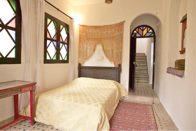 une chambre avec un lit dans une pièce avec une fenêtre dans l'établissement Dar Rass El Maa, à Chefchaouen