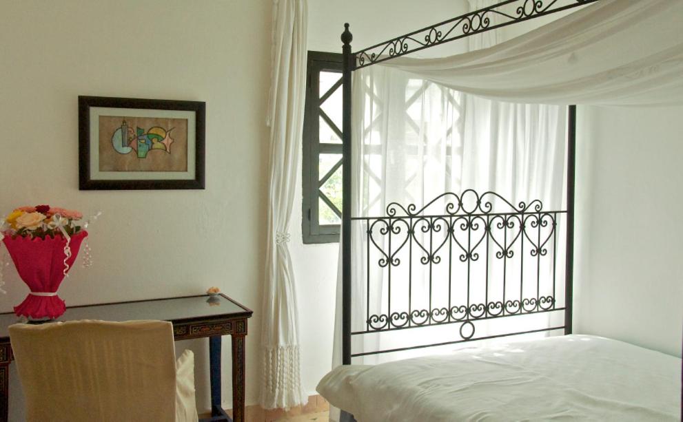 une chambre avec un lit, une table et une fenêtre dans l'établissement Dar Rass El Maa, à Chefchaouen