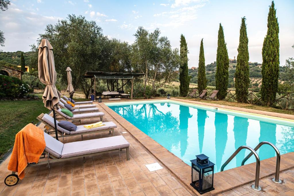 - une piscine avec des chaises longues à côté d'une villa dans l'établissement Villa in Agello, à Agello