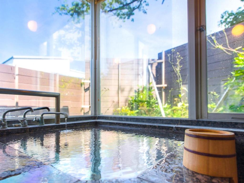 - une piscine en face d'une grande fenêtre dans l'établissement LiVEMAX RESORT Ito Kawana, à Itō