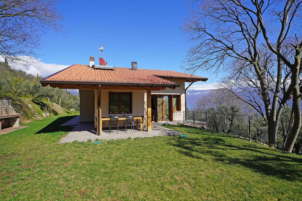 une petite maison avec un toit sur une pelouse dans l'établissement Ville in uliveto vista lago - VILLA LECCINO, à Pulciano