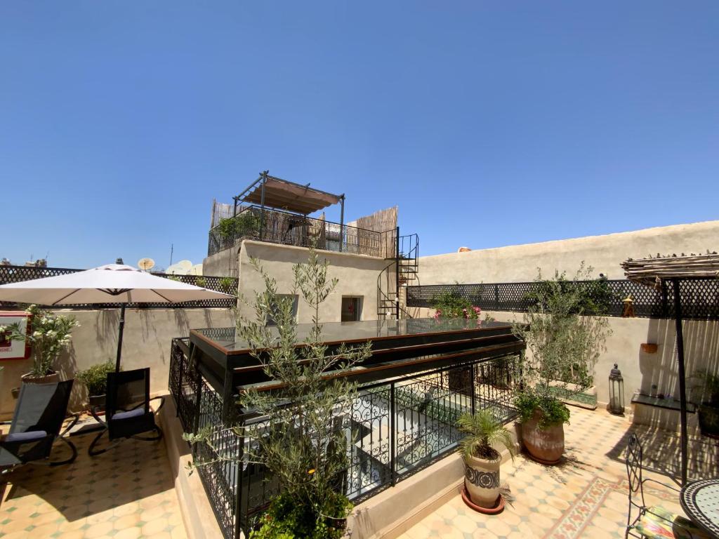 - un balcon avec une terrasse dotée de chaises et d'un parasol dans l'établissement Riad magnolia privé, à Marrakech