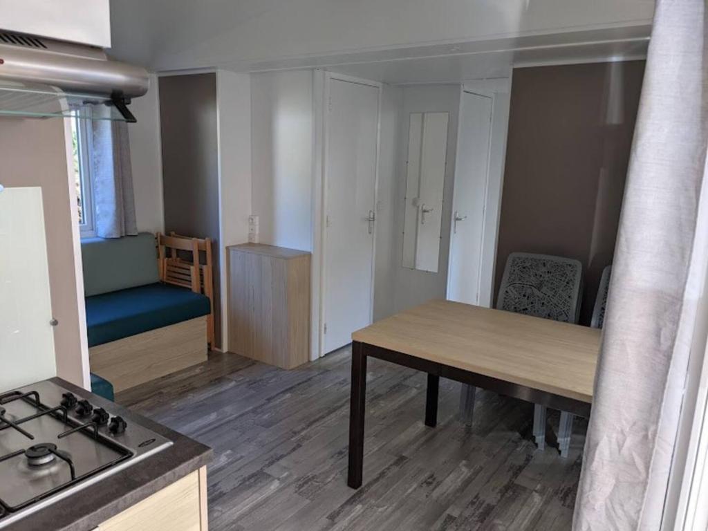 une petite cuisine avec une table et une cuisinière dans l'établissement Camping 4 étoiles RIVAGES DES LANDES anciennement Domaine Eurolac, à Aureilhan 4 autres photos
