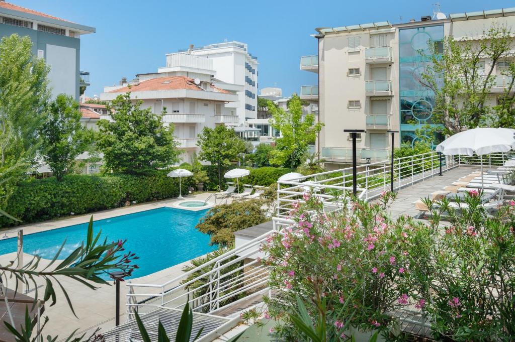 une piscine au milieu d'une ville avec des bâtiments dans l'établissement Hotel Maddalena, à Riccione