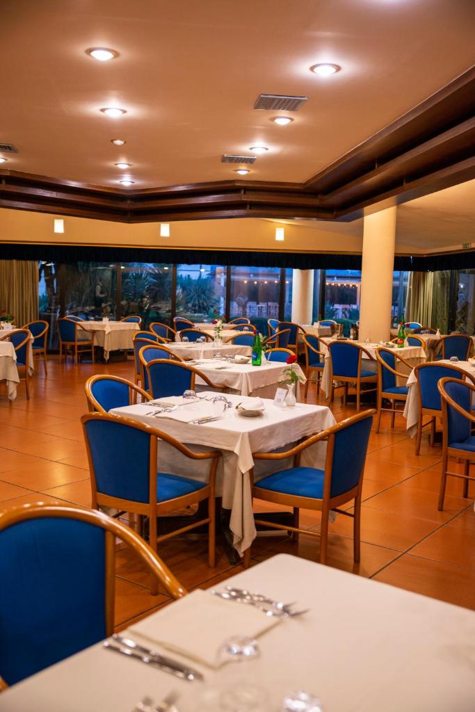 une salle à manger avec des tables et des chaises bleues dans l'établissement Hotel Schuhmann, à Paestum