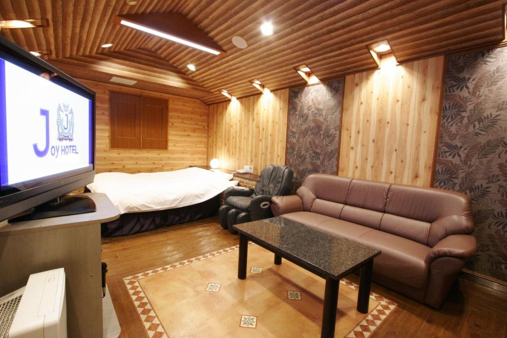 une chambre avec un canapé, un lit et une télévision dans l'établissement Hotel Joy (Adult Only), à Komaki 26 autres photos