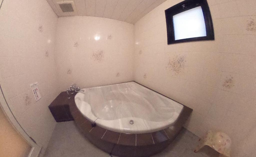une grande baignoire dans une salle de bain avec une fenêtre dans l'établissement Hotel.COM (Adult Only), à Nagoya 13 autres photos