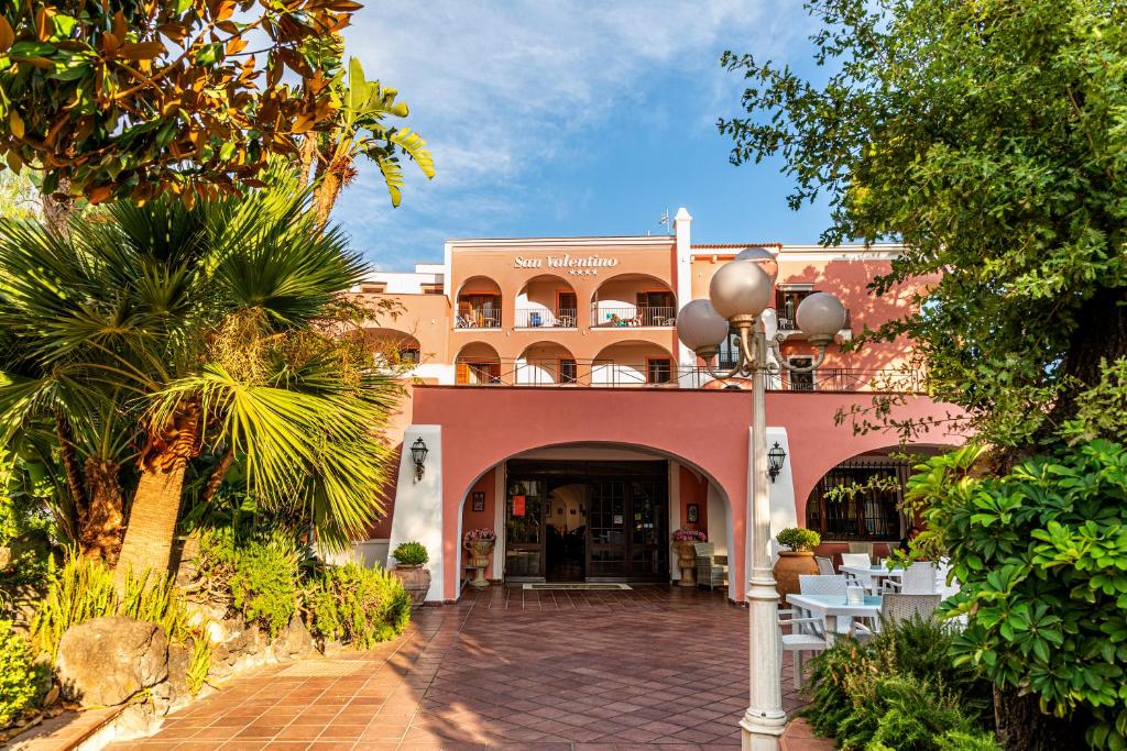 un bâtiment avec une cour avec des tables et des chaises dans l'établissement Hotel San Valentino Terme, à Ischia