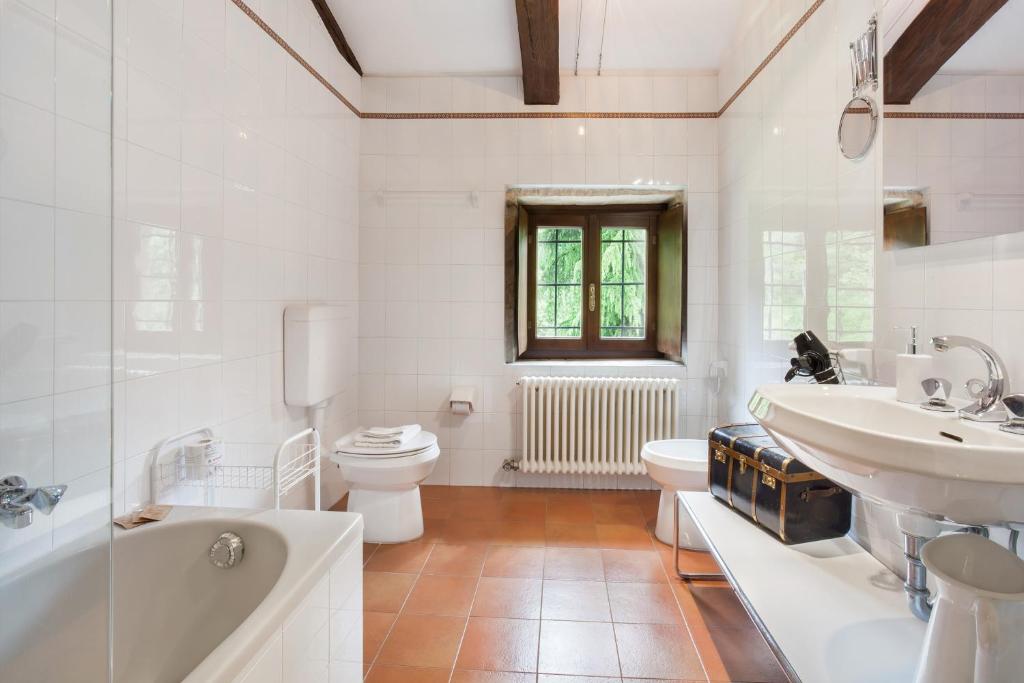 une salle de bain avec un lavabo, des toilettes et une baignoire dans l'établissement Villa Sibilla Il Giardino Di Sibilla With Pool, à Monte San Lorenzo