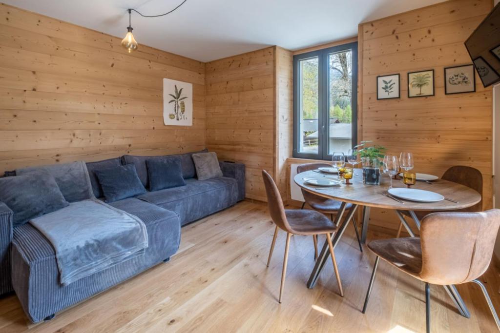 un salon avec un canapé bleu et une table dans l'établissement Newly renovated apartment with Mont Blanc view, à Chamonix-Mont-Blanc