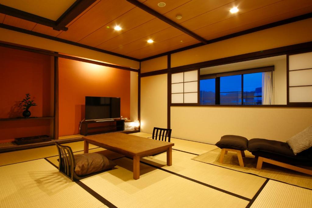 un salon avec une table et un canapé dans l'établissement Hokuriku Yamashiro Onsen Hotel Kikyou, à Yamashiro