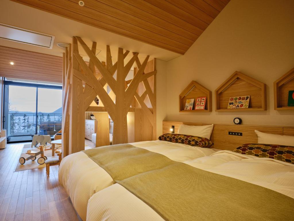 - une chambre avec 2 lits et une fresque murale sur les arbres dans l'établissement Lake Toya Tsuruga Resort HIKARINOUTA, à Lac Tōya
