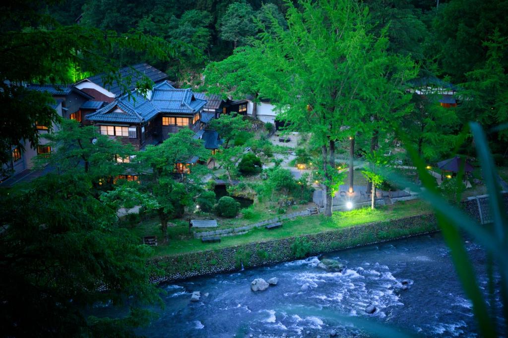 une vue aérienne d'une maison au bord d'une rivière dans l'établissement Rankeisou, à Sanjo