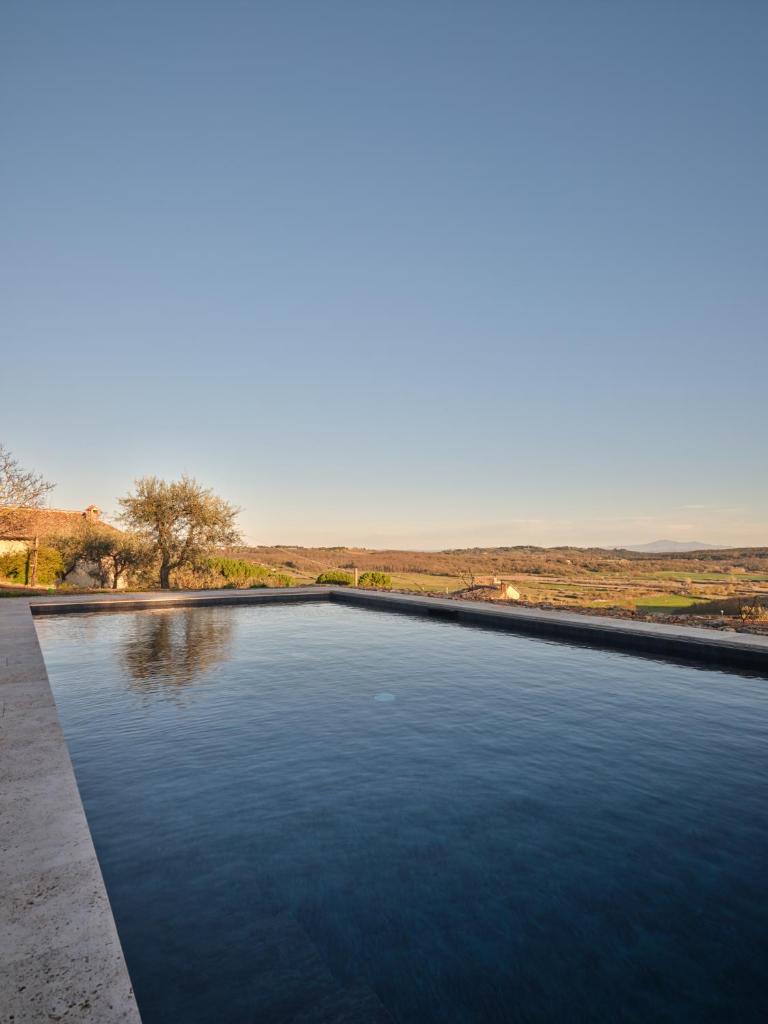 une piscine au milieu d'un champ dans l'établissement Il giardino sotto le stelle, à Fungaia