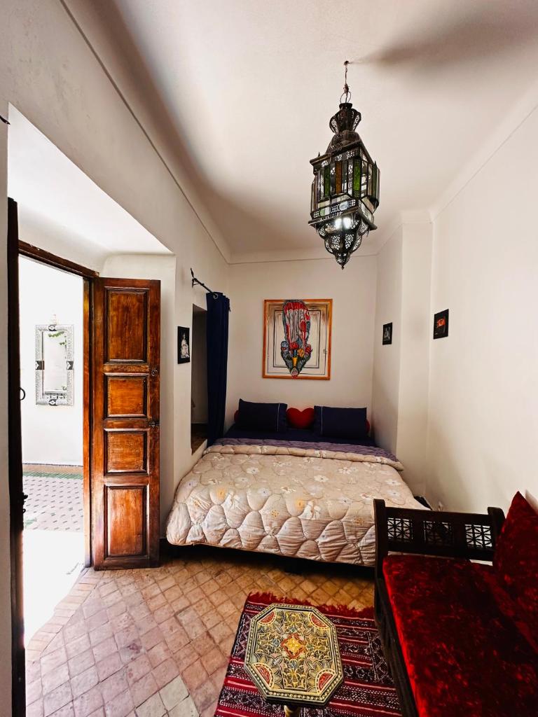 une chambre avec un lit et un lustre dans l'établissement Riad MsHolidays bassin privatisé Marrakech, à Marrakech