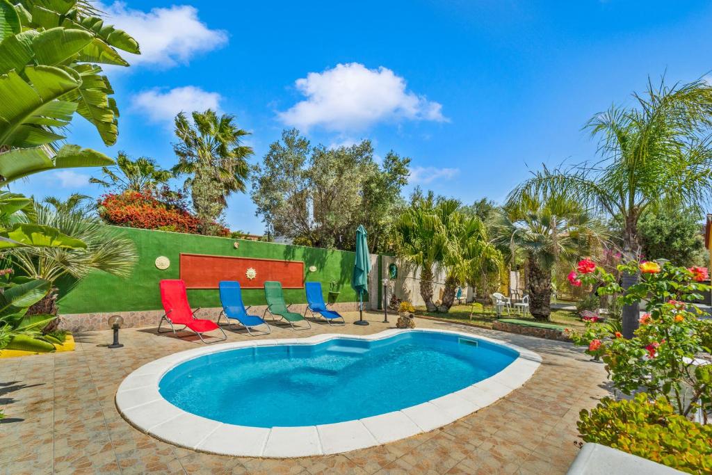 une piscine avec des chaises longues et une table dans l'établissement Villa Angela, à Quartu SantʼElena