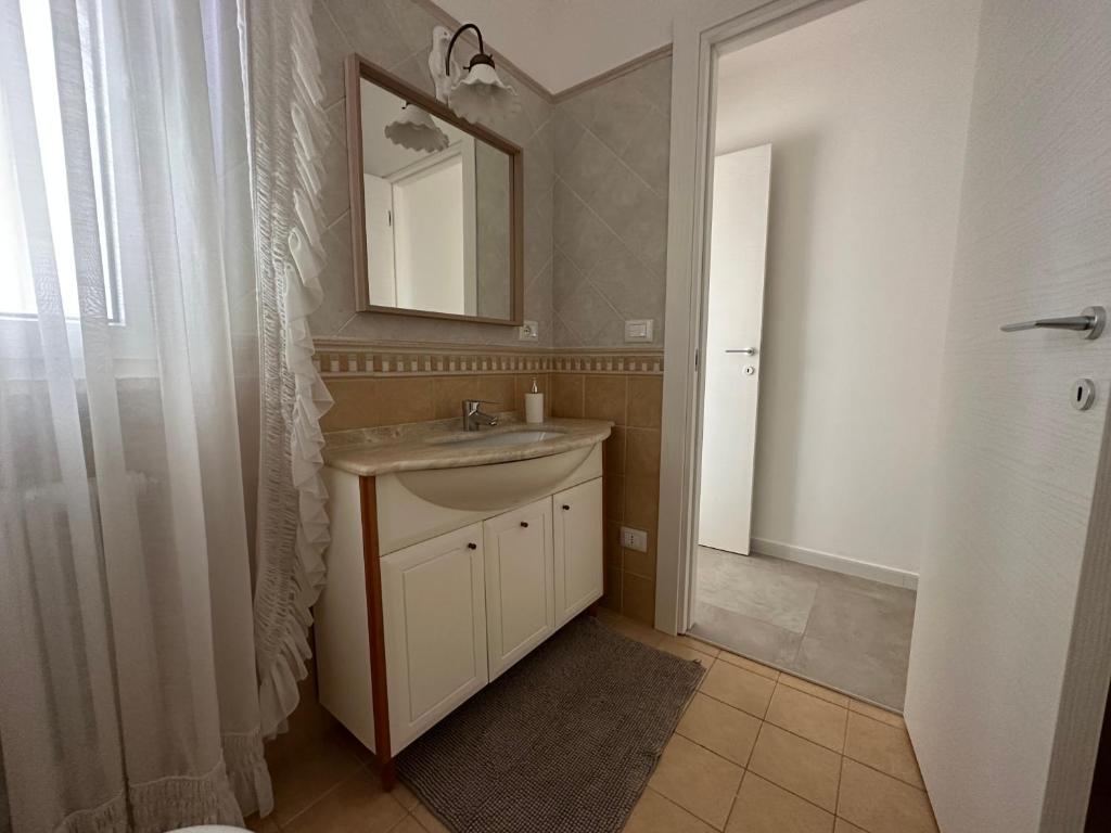 une salle de bain avec un lavabo et un miroir dans l'établissement Villa Antonia sul mare con piscina Torre a mare (Bari), à Bari