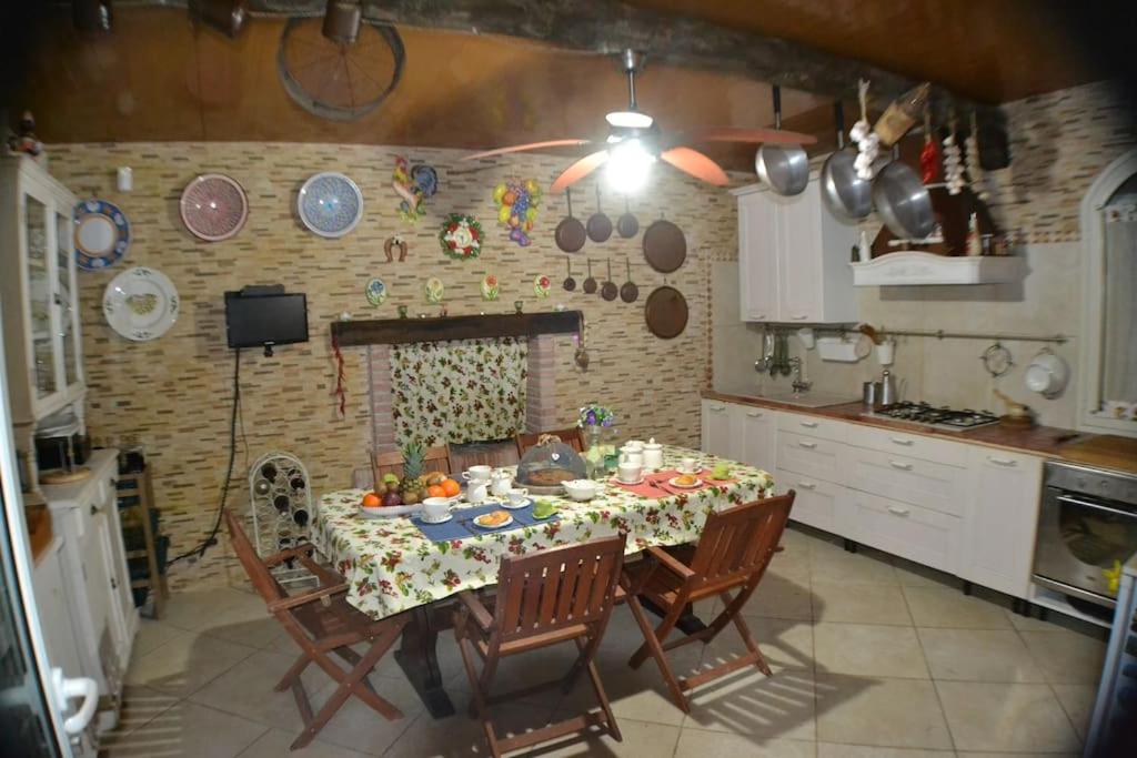 une cuisine avec une table et des chaises dans une cuisine dans l'établissement Borgo Guastaferri Villa & Pool !, à Oria