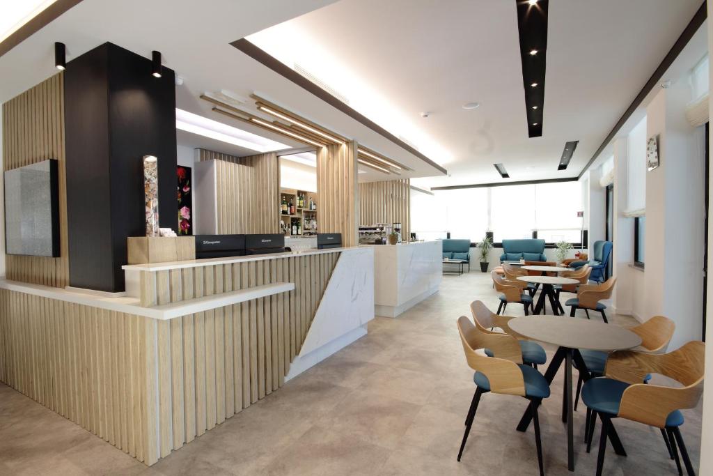 un hall de bureau avec des tables, des chaises et un comptoir dans l'établissement Hotel Toledo, à Lido di Jesolo