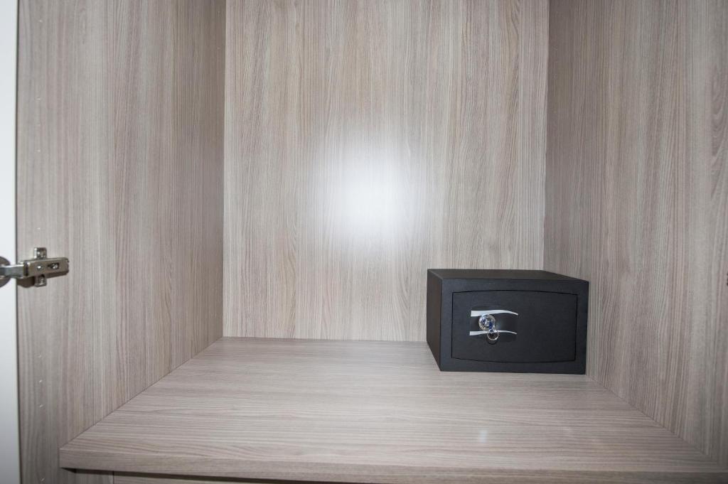 une télévision posée sur une étagère en bois dans une pièce dans l'établissement Hotel Sorriso, à Misano Adriatico