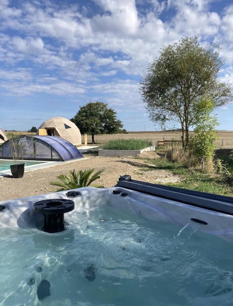 - un bain à remous dans un champ avec une tente en arrière-plan dans l'établissement A l'aube des sens, à Bailly-le-Franc