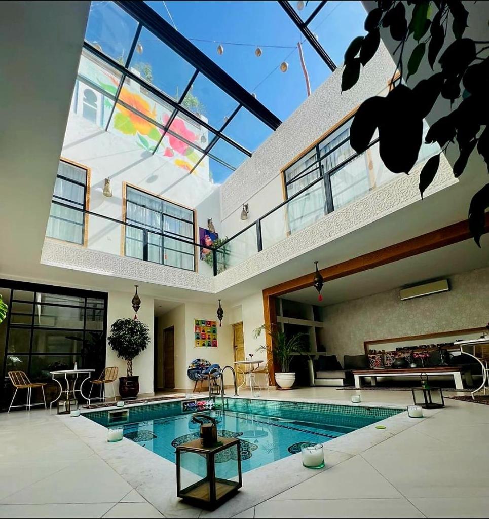 - une grande piscine dans une maison dotée d'un grand plafond dans l'établissement Riad Tsar Mimoun, à Marrakech