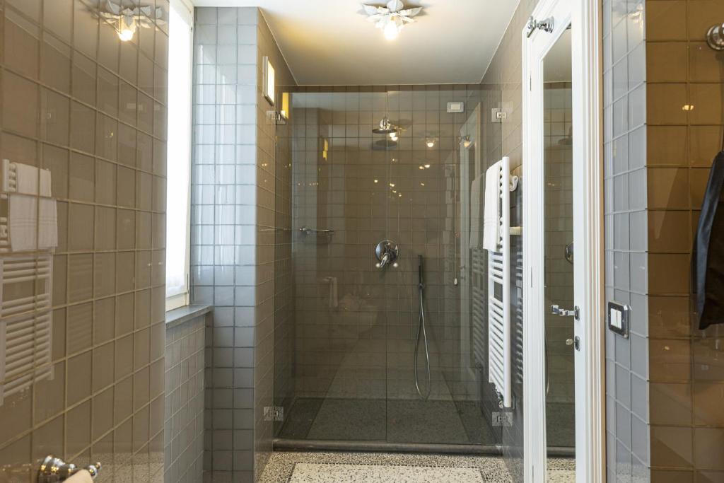 une douche avec une porte vitrée dans une salle de bain dans l'établissement Roccobarocco Boutique Hotel, à Ischia