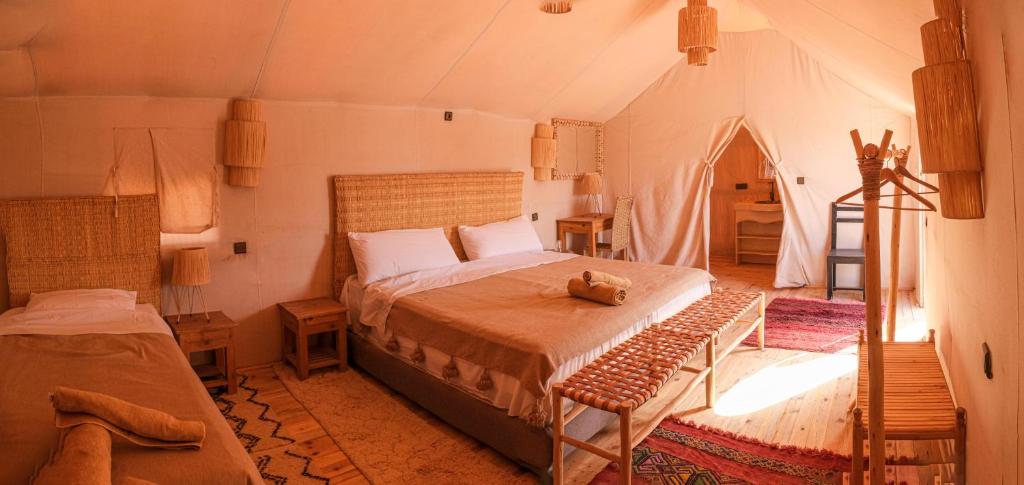 une chambre avec un lit dans une tente dans l'établissement riad sbai palace, à M'Hamid El Ghizlane 37 autres photos