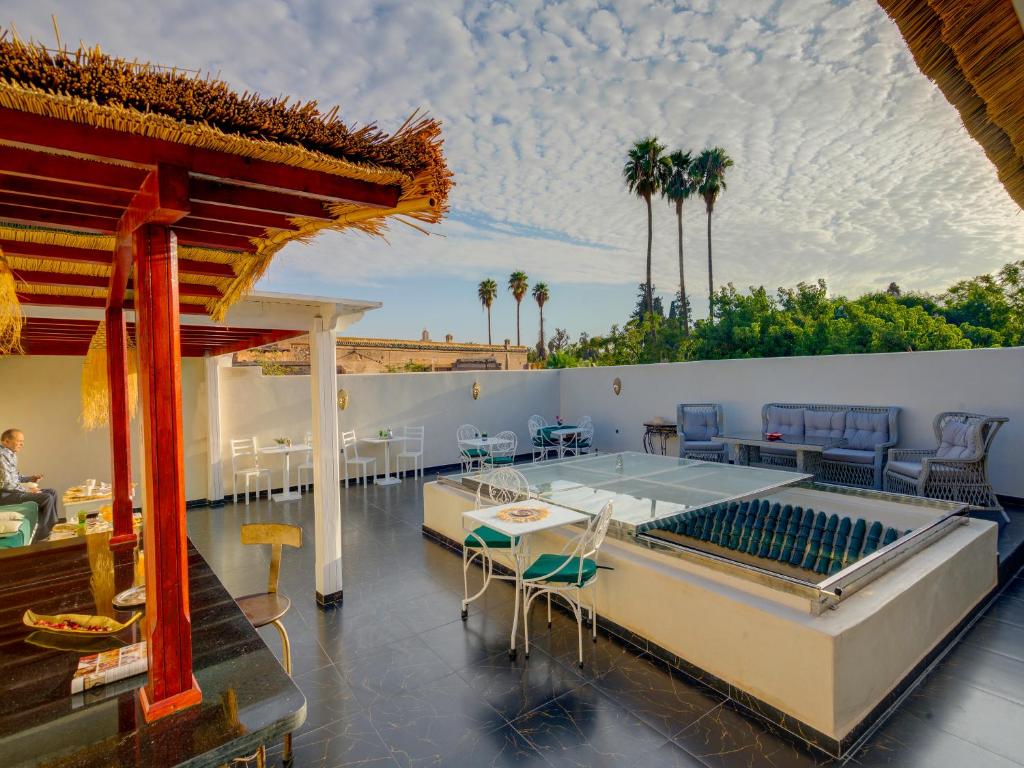 un patio avec une table et des chaises sur un bâtiment dans l'établissement Riad Princesse Du Désert & Spa, à Marrakech